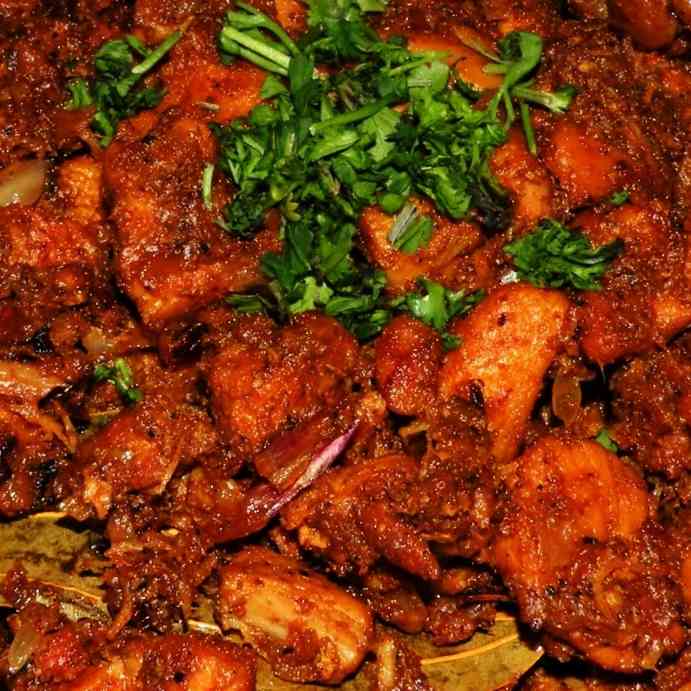 Spicy and aromatic chicken varuval showcasing perfectly seasoned and seared chicken pieces with a medley of South Indian spices for a delicious and flavorful culinary experience